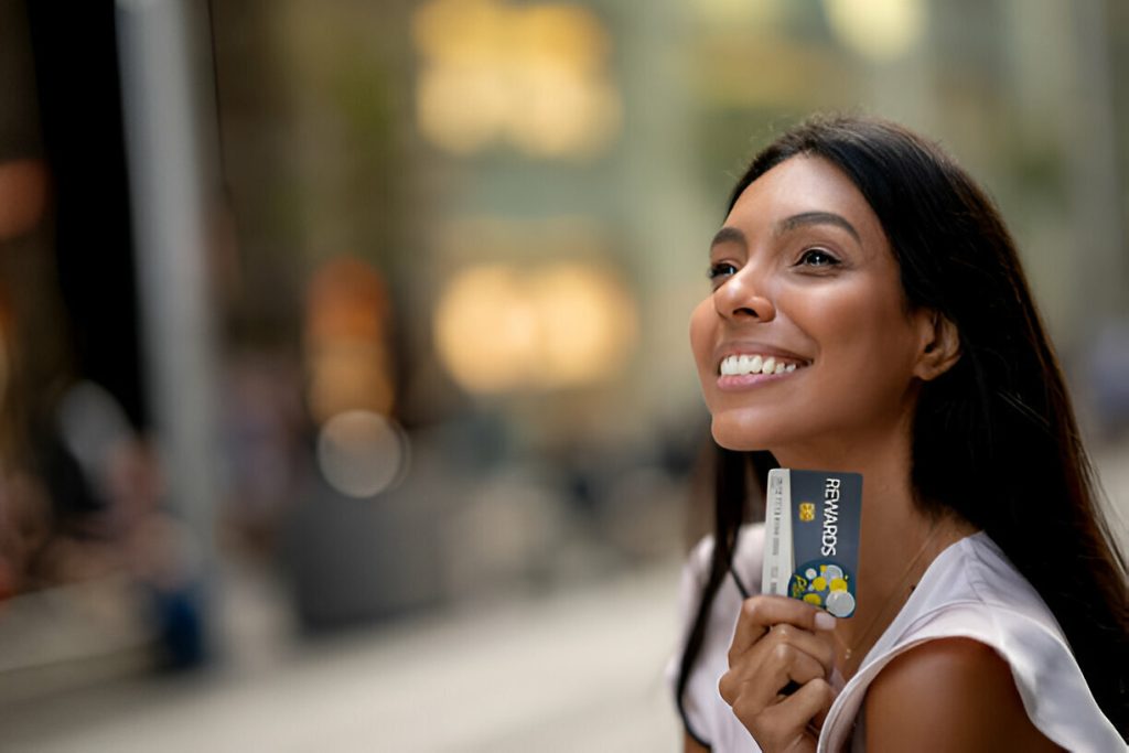 Portrait of a happy shopping woman holding a rewards card and smiling