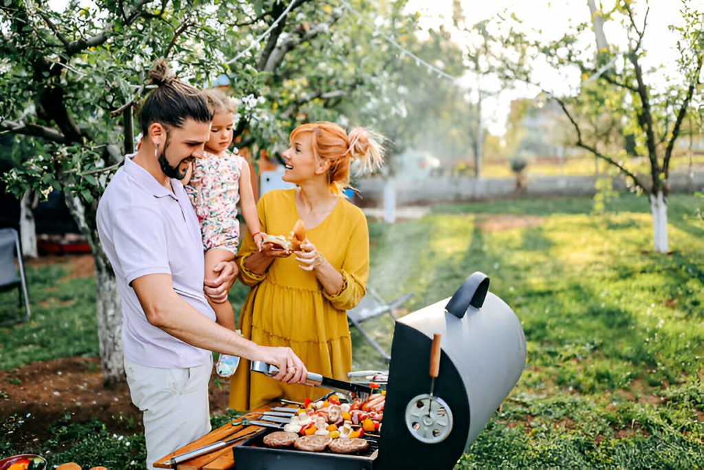 Family preparing meal in backyard on barbecue grill