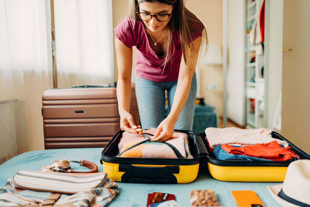 Woman packing suitcase for summer travel and using smart tag