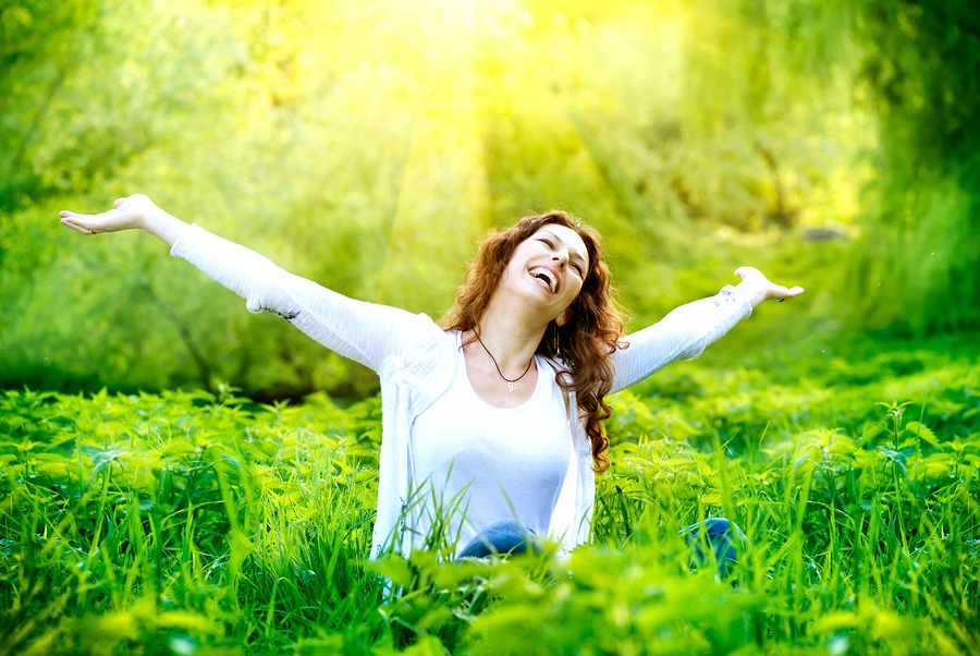 Beautiful Young Woman Outdoors. Enjoy Nature. Healthy Smiling Girl in Green Grass.